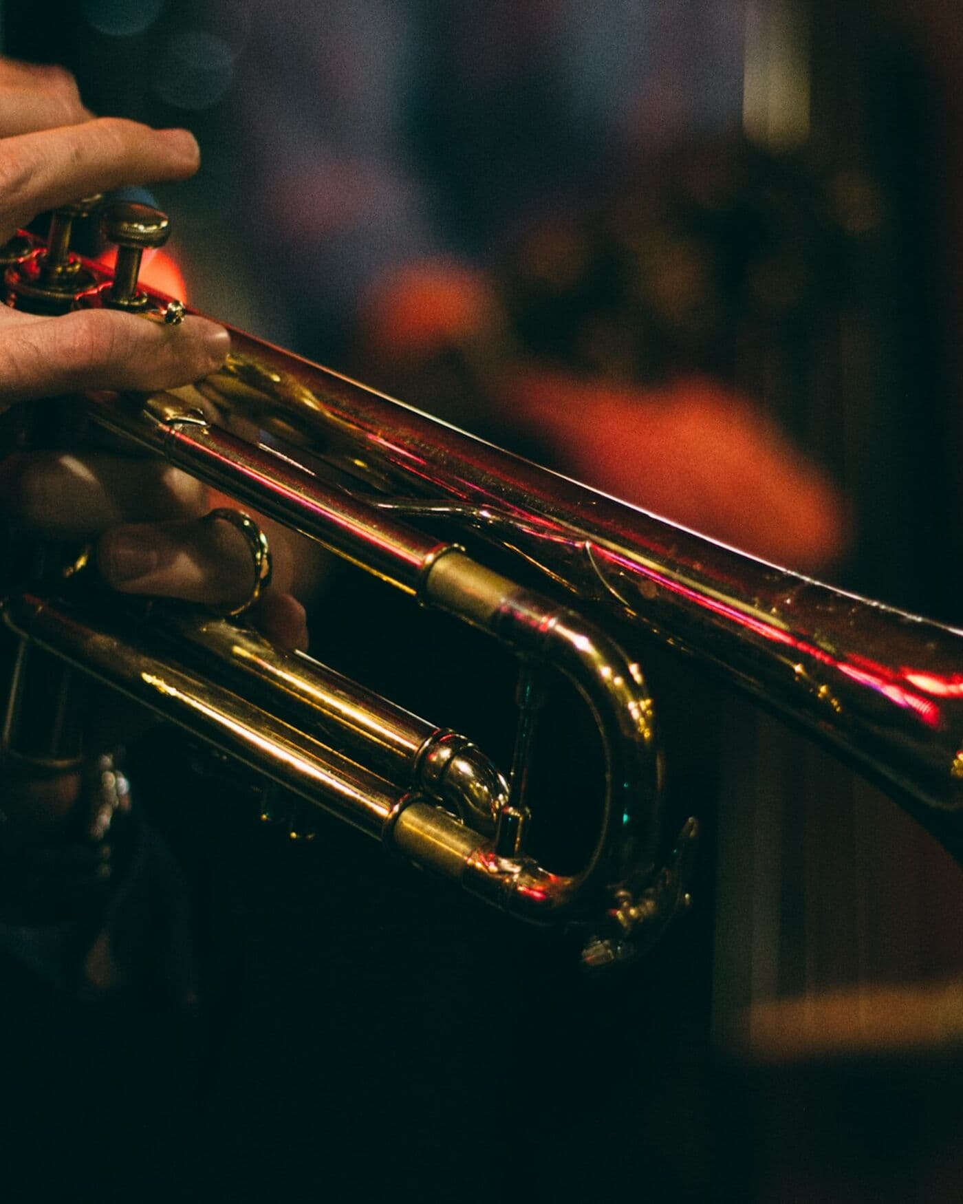A trumpet player on a small stage at night